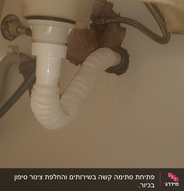 צינור ניקוז לבן מתחת לכיור עם חיבורים